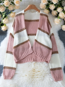 Close-up of pink and white striped knit cardigan with glitter thread and gold accents