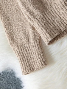 Vue détaillée des poignets côtelés d'un pull en maille beige à col en V oversize