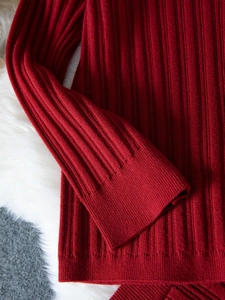 Detailed macro view of the red ribbed knit texture on long sleeve winter sweater