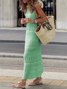 Detail of mint green sleeveless crochet knit dress with geometric cutout patterns
