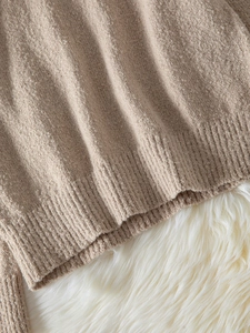 Gros plan détaillé des poignets côtelés et de la texture de l'ourlet d'un pull en maille abricot