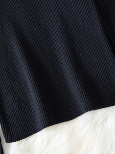 Close-up of black rib-knit fabric texture on a soft white faux fur background