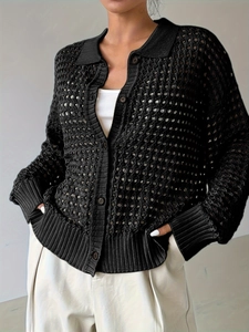 Dettaglio del cardigan nero in maglia traforata che mostra trama e bottoni rotondi