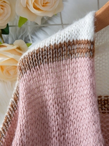 Detail of knit sweater neckline with metallic thread stripes and lantern sleeves