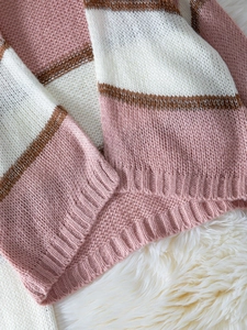 Detailed close-up of pink and brown striped knit sweater hem with ribbed texture details