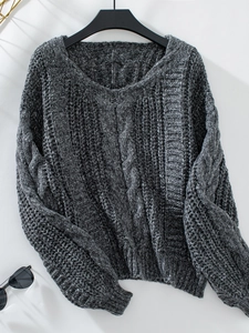 Detaillierte Textur aus Zopfmuster und Strickgewebe an einem dunkelgrauen V-Pullover
