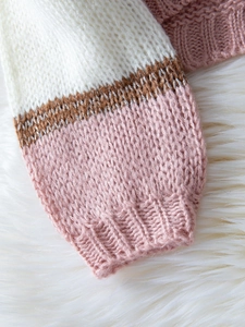 Detail view of ribbed cuffs on tri-color knit sweater with sparkling metallic yarn