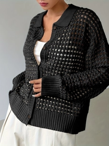 Dettaglio del cardigan nero in maglia all'uncinetto con trama traforata e risvolto