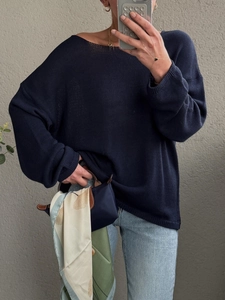 Dettaglio della maglia blu navy con foulard in seta a fantasia su una borsa elegante