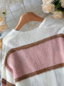 Detail of soft striped knit cardigan featuring white pink and brown wide color blocks