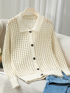 Dettaglio di cardigan in maglia traforata crema con colletto polo e bottoni scuri