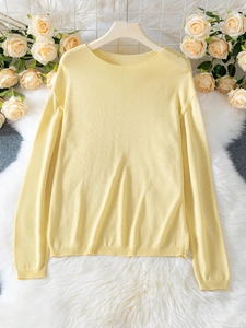 Dettaglio del maglione in maglia giallo chiaro con girocollo e polsini a coste su gruccia