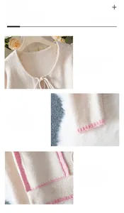 Detail view of cream knit cardigan featuring pink contrast edges and drawstring collar