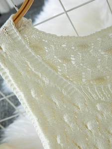 Close-up of cream knit hollow-out vest showing intricate crochet diamond textures