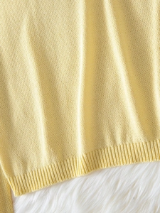 Dettaglio maglione in maglia giallo chiaro con trama fine e bordo a coste su pelliccia