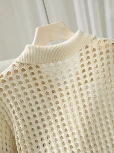 Dettaglio della trama in maglia traforata color crema e dello scollo rotondo a coste