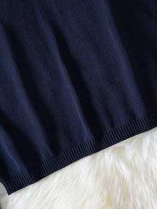 Dettaglio del maglione in maglia blu scuro con bordo a coste e trama di alta qualità
