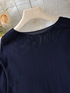 Dettaglio dello scollo del maglione in maglia blu navy e della morbida trama del tessuto