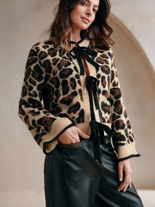 Détail du cardigan léopard avec nœuds papillon noirs élégants et texture en maille douce