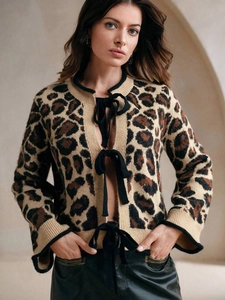 Détail du cardigan léopard avec fermetures chic par nœuds en ruban noir soyeux