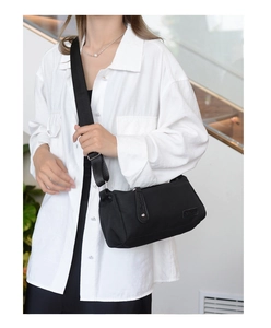 Detail of black crescent crossbody bag with adjustable wide strap and nylon texture