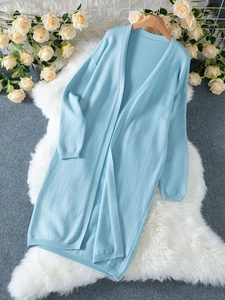 Mise à plat d'un long cardigan en maille bleu clair avec épaules tombantes