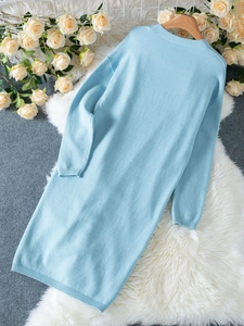 Détail d'un cardigan bleu clair en maille fine avec finitions côtelées et manches longues