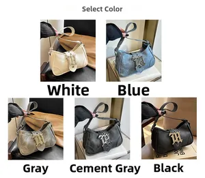 Détail de la boucle métallique gothique sur les sacs sous le bras en blanc et bleu