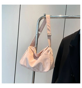 Detail of adjustable strap and silver metal buckle on light pink pleated hobo bag
