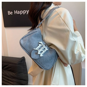 Gros plan sur le sac croissant en denim bleu avec une boucle décorative en métal argenté