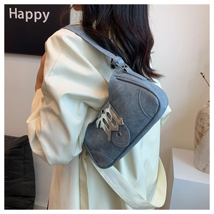 Détail du sac de selle en jean gris avec boucle métallique et large bandoulière
