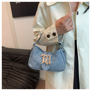 Détail du sac croissant en jean bleu clair avec une grande boucle en métal doré M