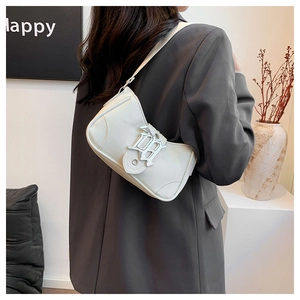 Détail d'un sac demi-lune en cuir blanc cassé avec une boucle en métal élégante