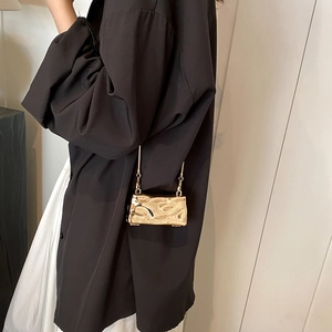 Chic gold metallic crossbody bag with textured fluid ripple design and chain strap