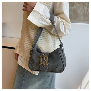 Détail du sac sous le bras en forme de croissant gris avec boucle dorée gothique chic