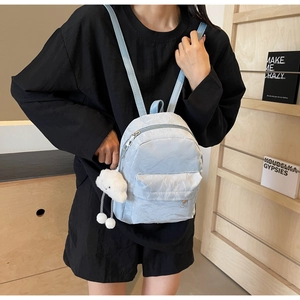 Light blue nylon mini backpack with plush cloud pendant shown on a model