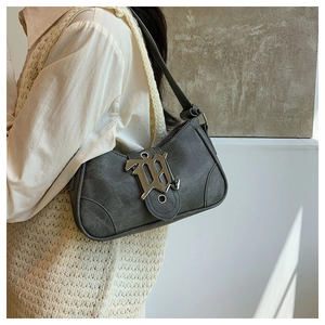 Détail du sac croissant gris foncé avec boucle H argentée vintage sur gilet en maille