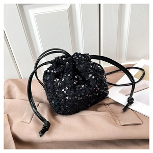 Détail du sac seau à paillettes noires avec cordon de serrage pour un style de soirée