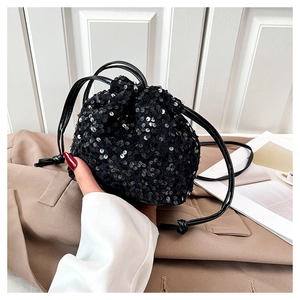 Détail d'un sac seau chic à paillettes noires avec fermeture à cordon coulissant