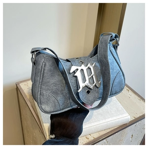Gros plan du sac croissant en denim lavé avec boucle métallique gothique et bandoulière