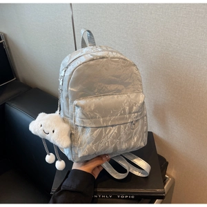 Detail of silver metallic backpack with crinkled texture and plush cloud keychain charm