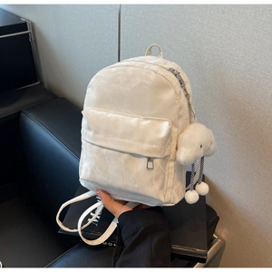 Detail of cream mini backpack with nylon texture and a cute white cloud plush pendant