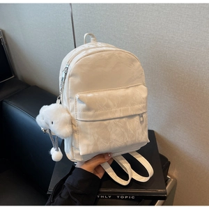 Detail of white nylon backpack with crinkled texture and cute cloud plush charm accessory