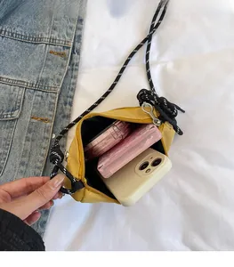 Vista interna della borsa a tracolla in nylon giallo con spazio per telefono e trucco