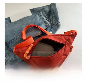 Interior view of bright orange nylon crossbody bag showing large capacity for wallets