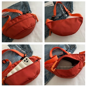 Detail view of orange crescent crossbody bag with adjustable strap and large capacity