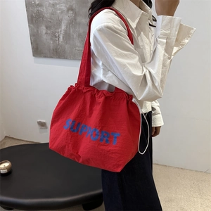 Red canvas tote bag with blue Support text and drawstring closure for daily commute