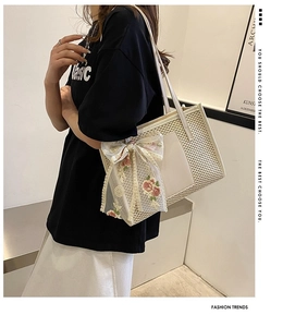 Detail of straw tote bag with lace bow, floral embroidery and leather trim shoulder strap