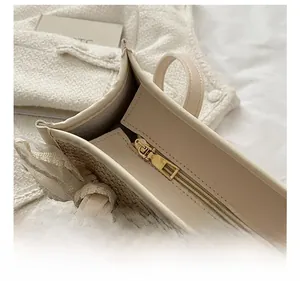 Detailed close-up of golden metal zipper hardware on a beige woven straw tote bag