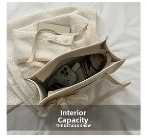 Top-down view of spacious woven straw tote bag interior with daily essentials and zipper